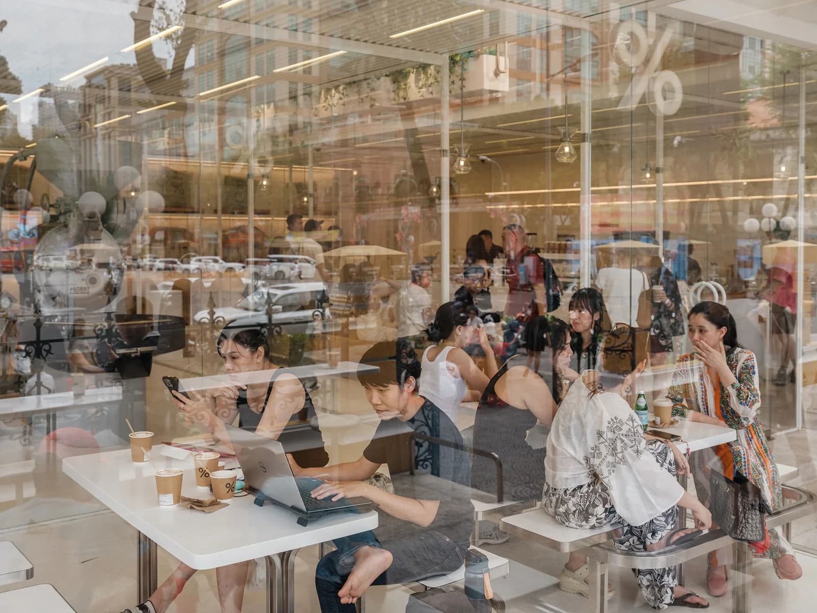 Customers seen through reflections in a coffee shop window in Ho Chi Minh City