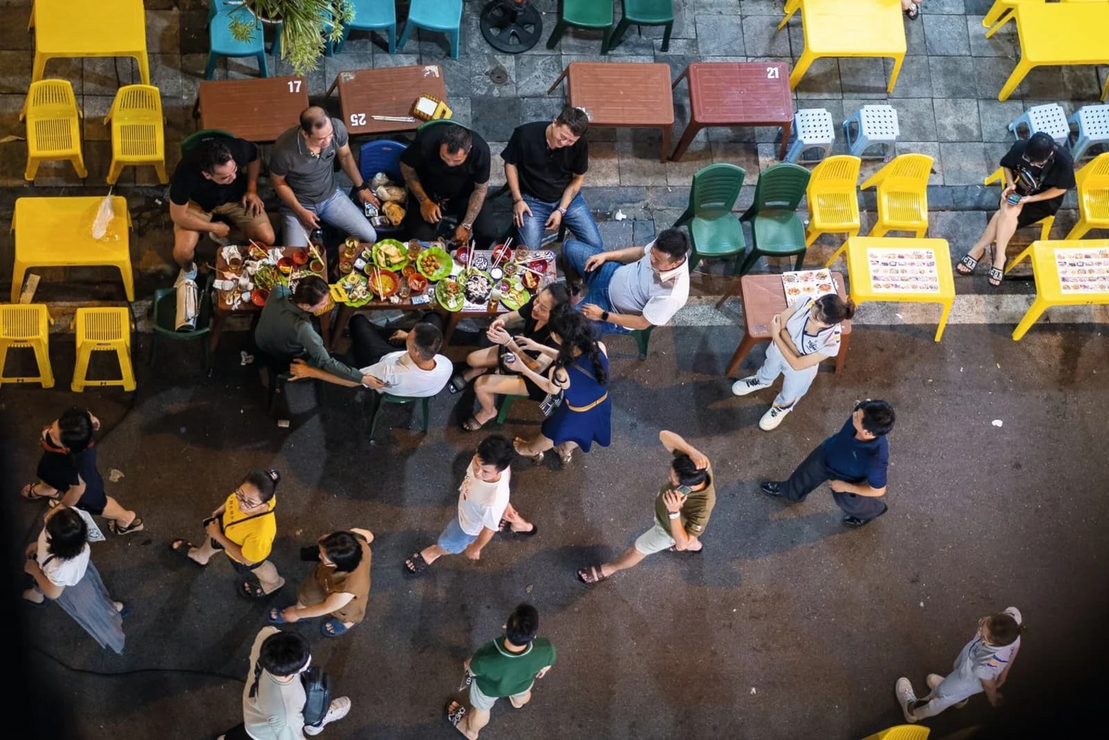 People gathering around small tables on Hanoi’s Beer Street at night